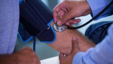 Male doctor checking blood pressure of patient